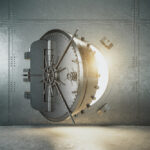 A heavy round steel vault door standing slightly open in a riveted metal wall, with warm light spilling out from inside.